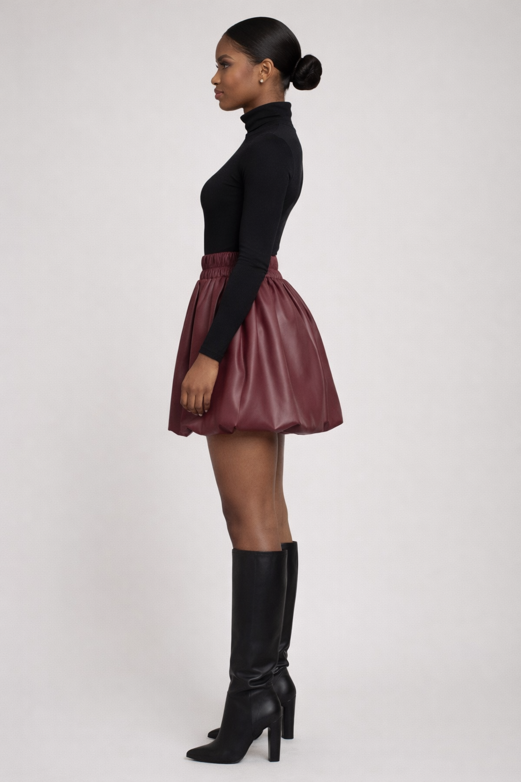 Side view of wine faux leather bubble skirt showing elastic waistband and structured silhouette